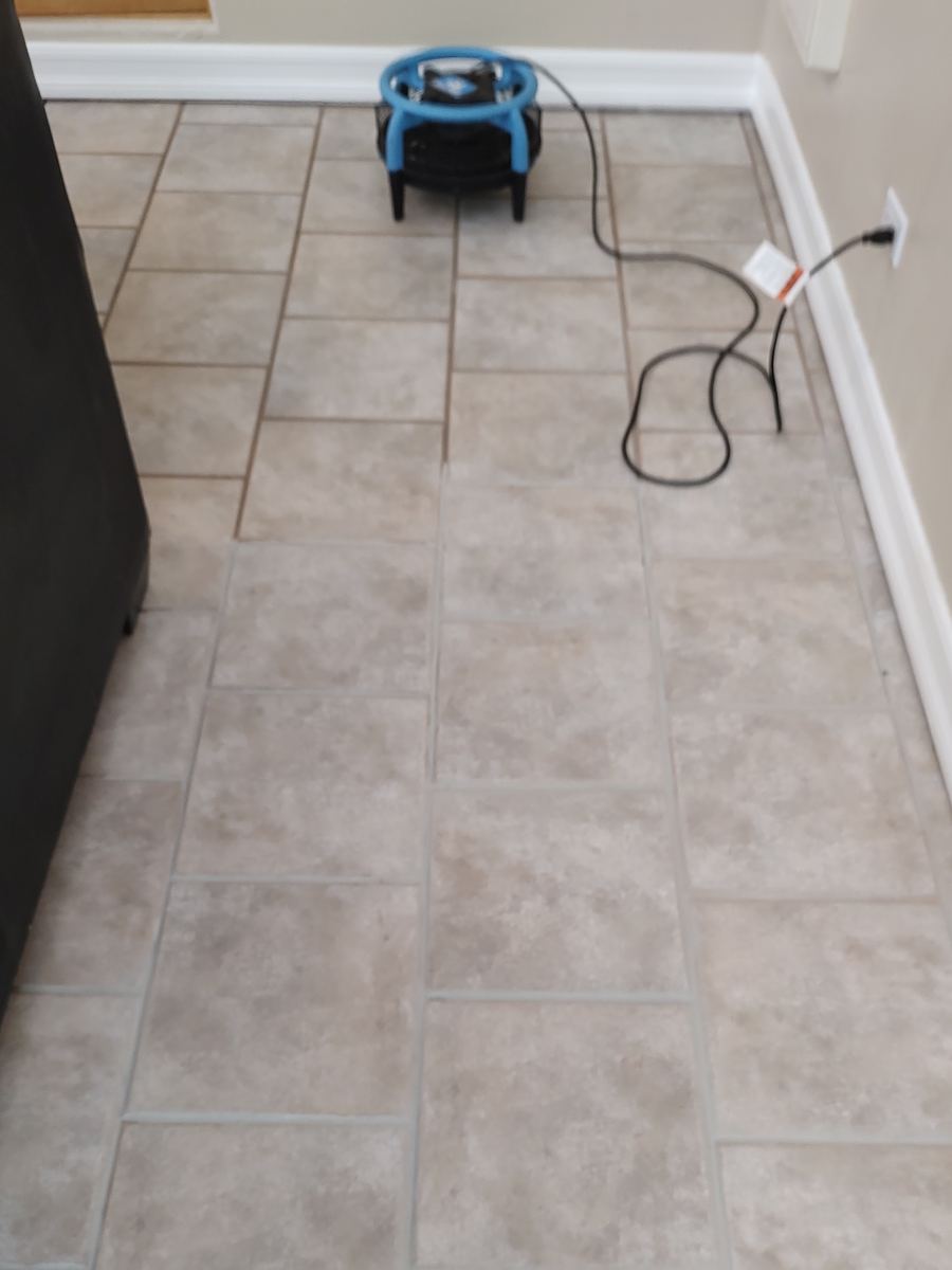 Hallway tile floor: the original dark brown grout lines at the far end, recolored light grout in the foreground